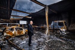 Ondernemer kijkt om zich heen in uitgebrand bedrijfspand