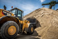Laadschopmachine pakt zand uit een zanddepot bij een bedrijf dat bouwgrondstoffen levert.