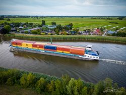 Drone foto binnenvaartschip met containers op de IJssel