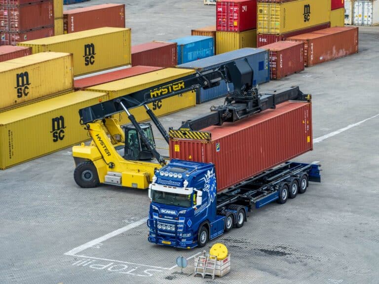 Reachstacker plaatst container op trailer,