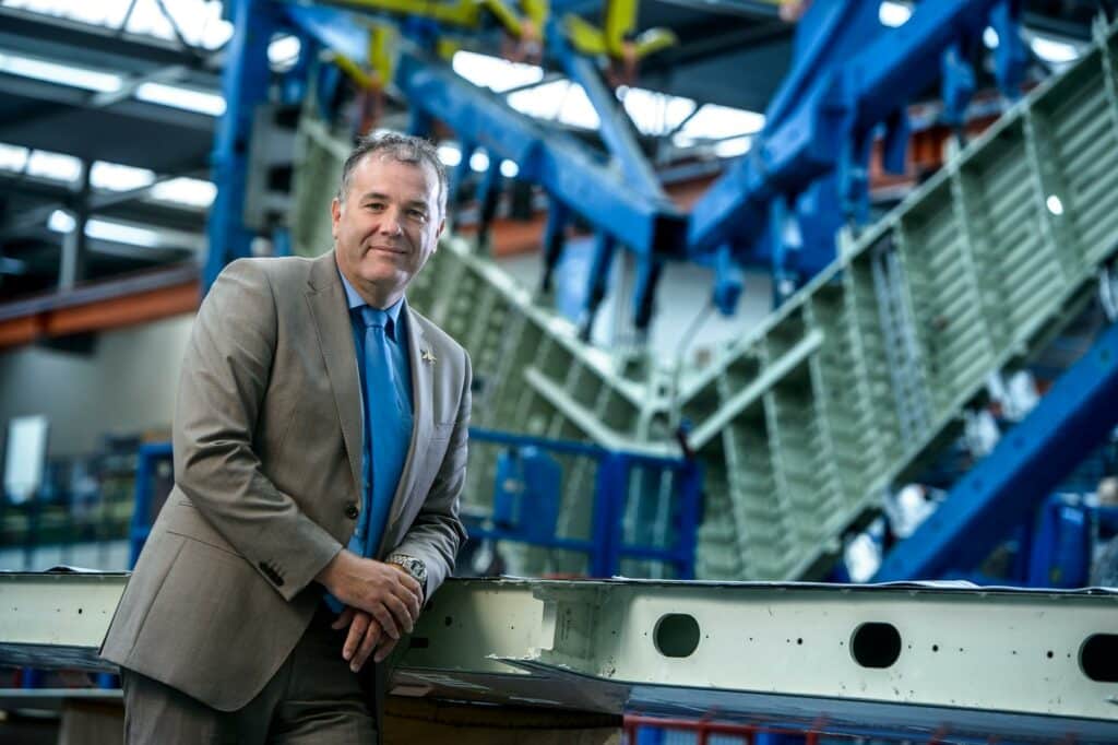 Portret CE Fokker in productiehal van de vleugel van een Gulfstream business jet