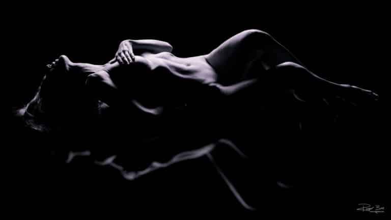Dame liggend op een reflecterende plaat - bodyscape boudoirfotografie in de studio