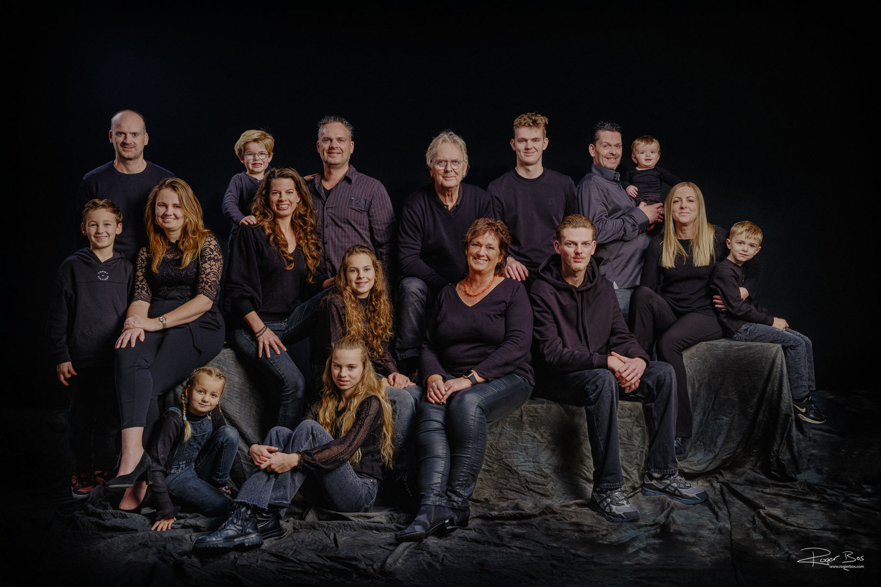 Familieportret tegen zwarte achtergrond met rembrandtlicht. Opa en Oma, de kinderen en alle kleinkinderen, Familieportret gemaakt in de studio in Rotterdam.