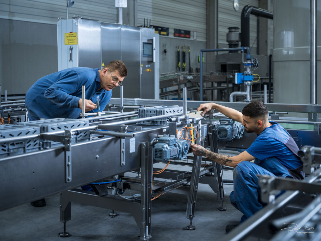 Monteurs stellen de loopbanden naar de industriële wasmachines af.