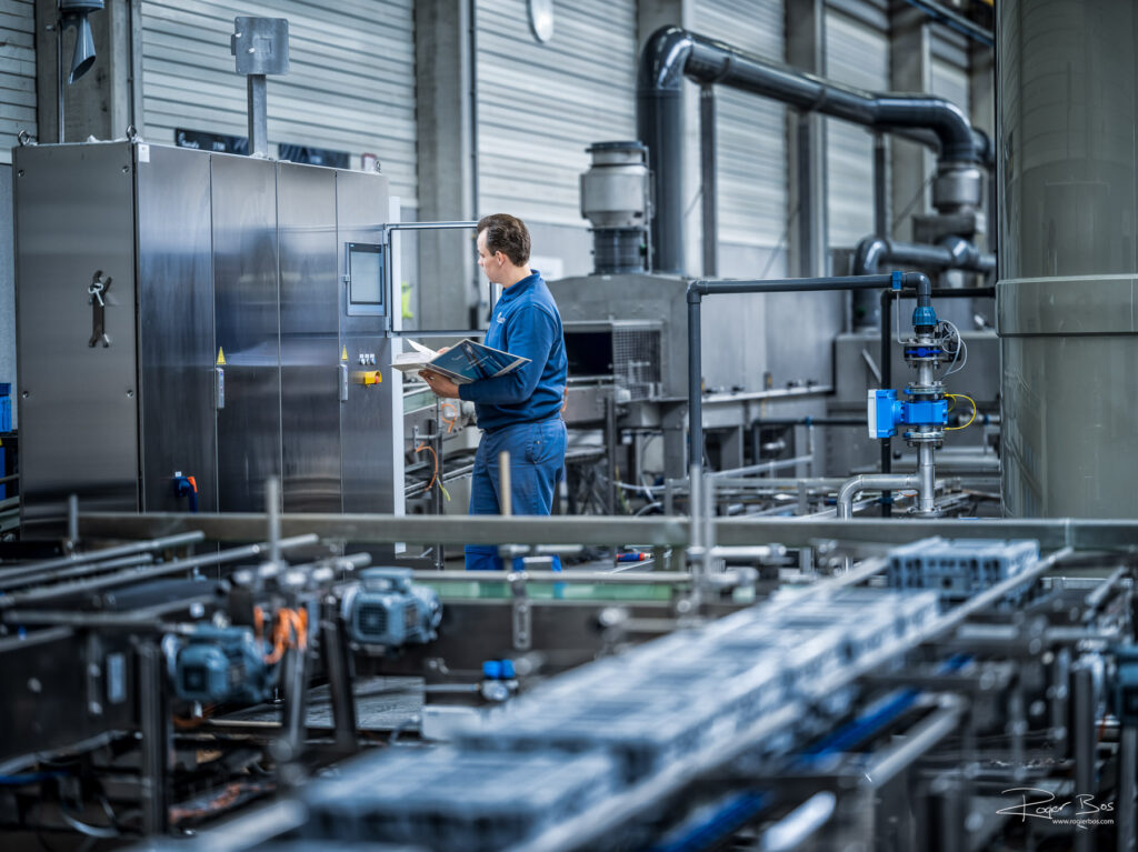 Servicemonteur bekijkt het industriële reinigings- en handlingsysteem dat opgesteld staat in de productiehal van Numafa, met service handleiding.