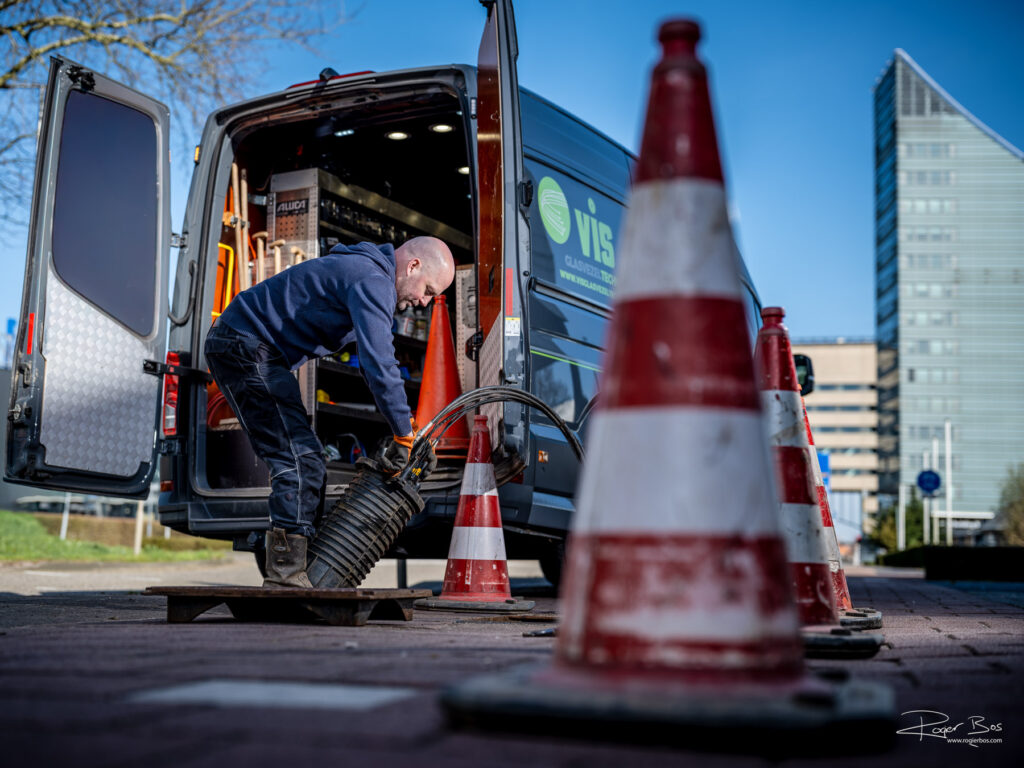 Glasvezelspecialist aan het werk bij bedrijfsgebouwen