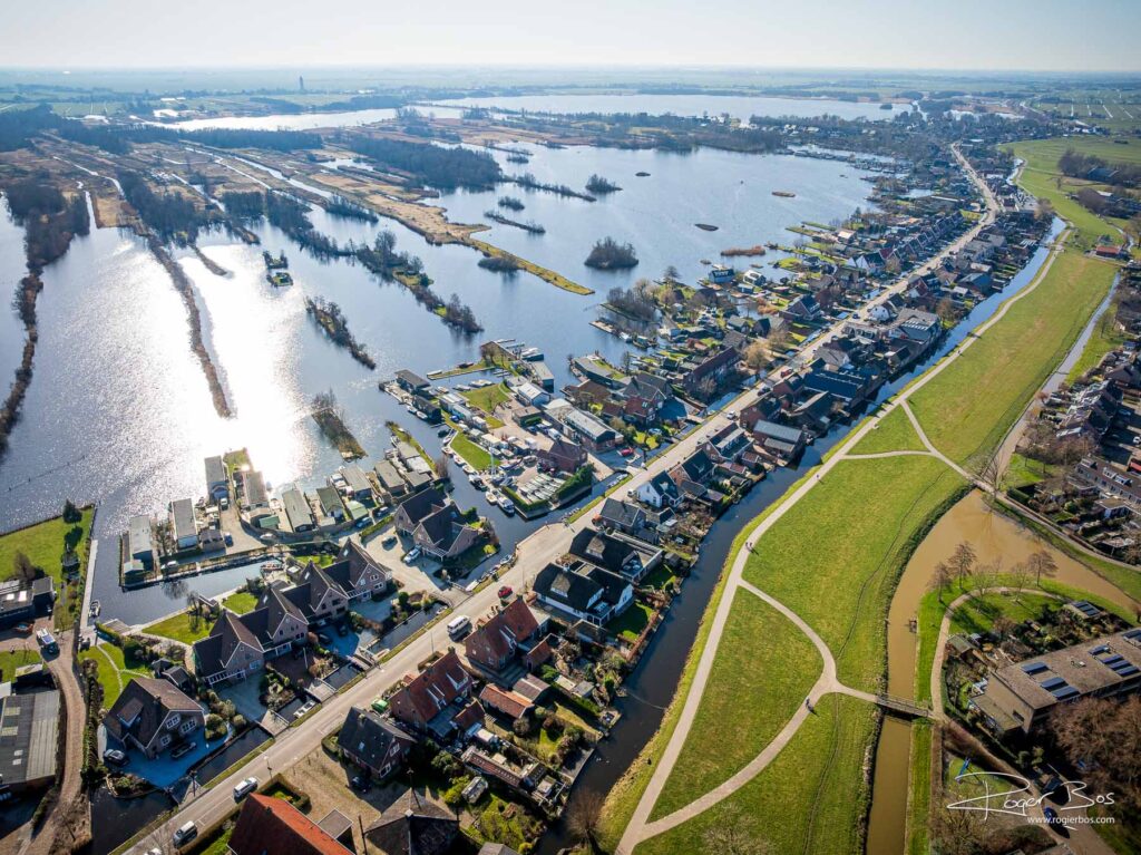 Luchtfoto van Kaag en Braassem met bijzonder landpatroon in het water en woonwijk aan de oever