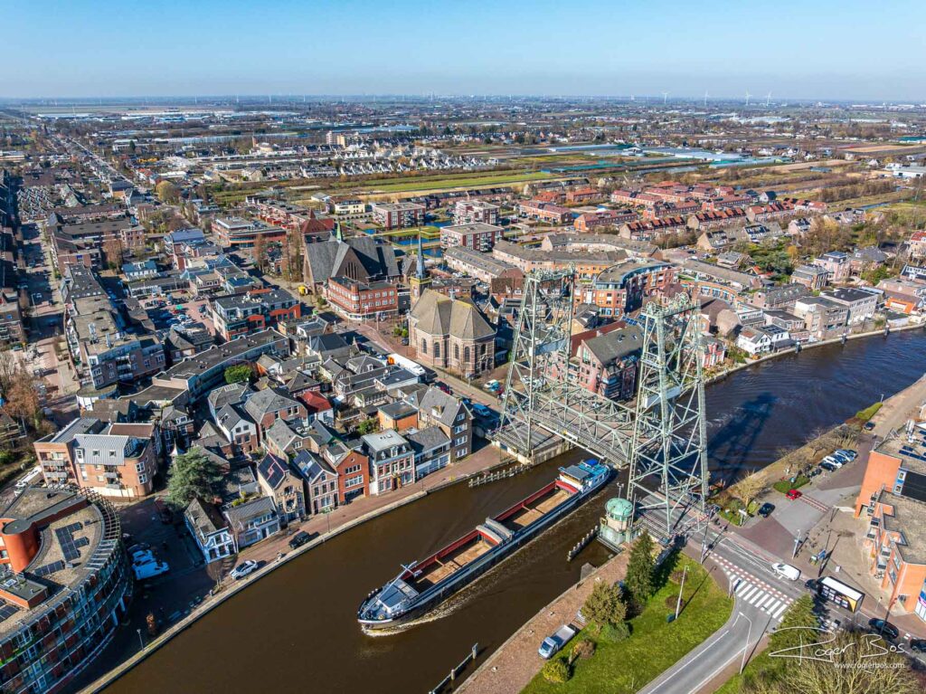 Luchtfoto van Alphen aan den Rijn met een schip dat onder de iconische hefbrug doorvaart