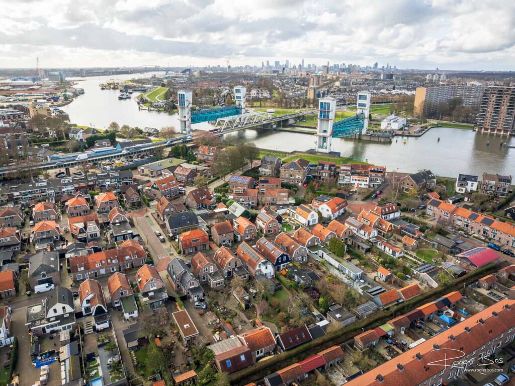 Dronefoto van Krimpen aan den IJssel met de Algerabrug over de Hollandse IJssel en de skyline van Rotterdam op de achtergrond