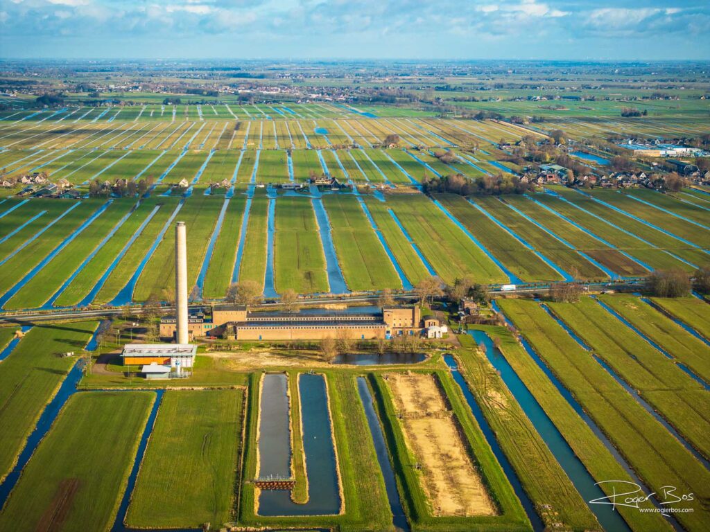 Dronefoto van de Krimpenerwaard met rivierwaterpompstation en karakteristiek polderpatroon van sloten en weilanden
