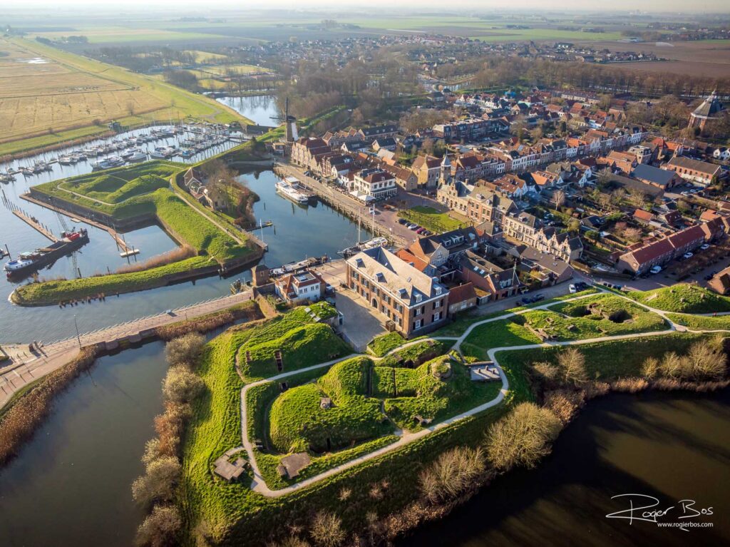 Dronefoto van Willemstad met stervormige vestingwerken, jachthaven en historische binnenstad in het ochtendlicht