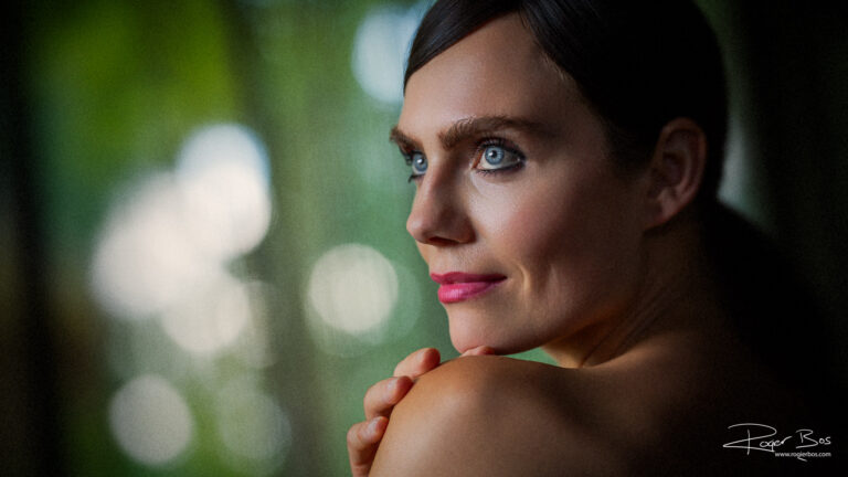 Professioneel portret van een vrouw met blauwe ogen, gefotografeerd door portretfotograaf Rogier Bos, waarin haar sterke en mooie kanten subtiel worden benadrukt.