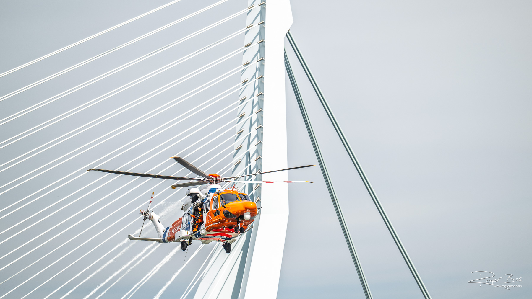 Kustwacht helikopter voor de Erasmusbrug in Rotterdam vastgelegd door professioneel fotograaf