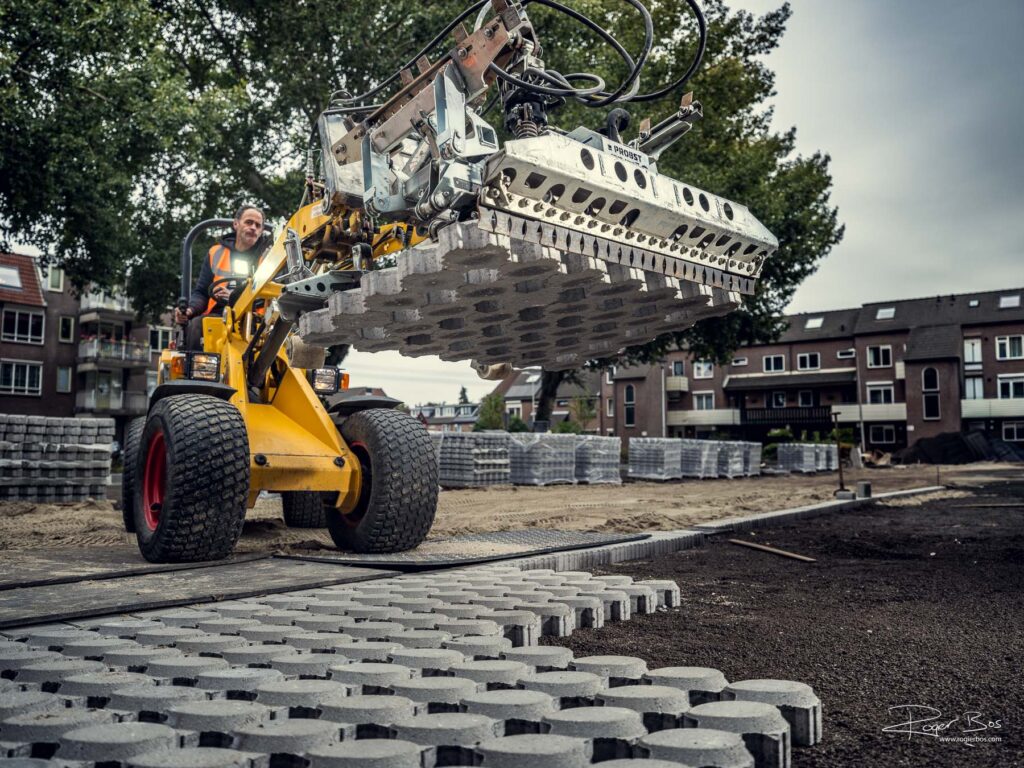 Medewerker van de Bunnik Groep brengt machinaal bestrating aan met een elektrische machine tijdens een infraproject in Capelle aan den IJssel – industriële foto door Rogier Bos.