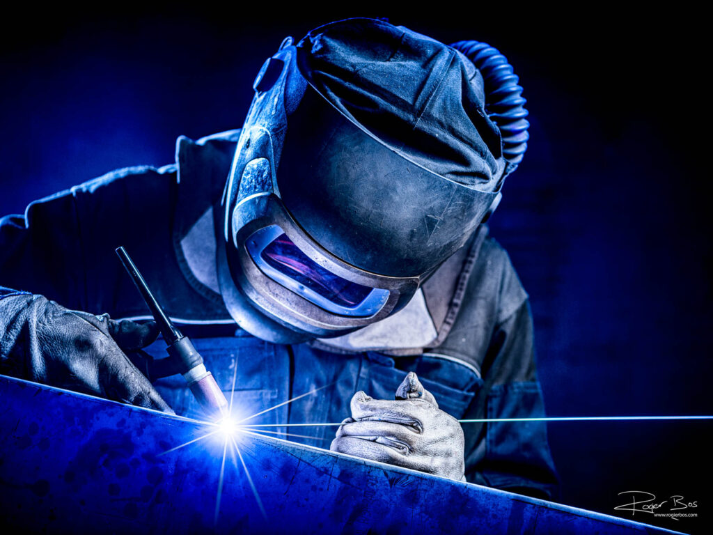 Industriële fotograaf legt TIG-lasser vast die met uiterste precisie werkt aan staalbewerking, gefotografeerd in hoge resolutie.