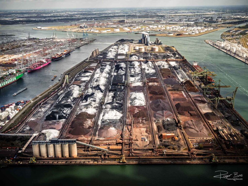 Luchtfoto van de Maasvlakte Rotterdam met bulkterminals van EMO en HES tussen de Mississippihaven en Amazonehaven, met grote voorraden steenkool en ertsen.