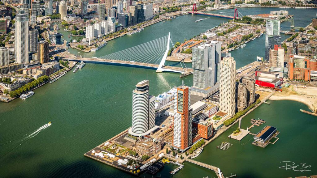 Luchtfoto van de Kop van Zuid in Rotterdam met de Erasmusbrug, Wilhelminapier, Hotel New York, hoogbouw en de Willemsbrug.