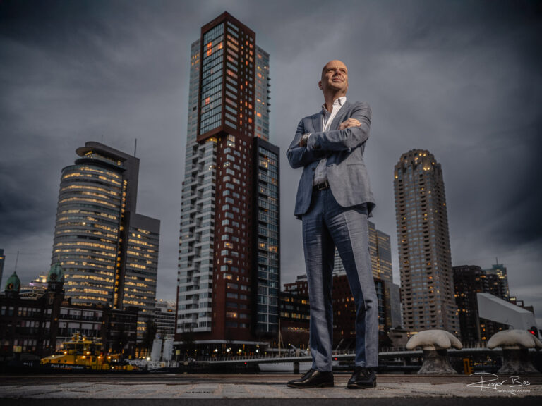 Portret van een CEO in pak gefotografeerd aan de Rijnhaven in Rotterdam met de Kop van Zuid op de achtergrond, gemaakt door professioneel portretfotograaf Rogier Bos.