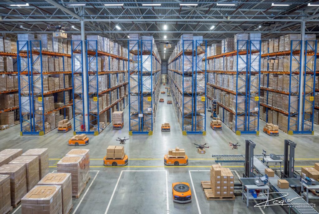 AI beeld van High tech magazijn met geautomatiseerde logistiek, robots, drones en opslagstellingen voor efficiënte goederenstromen.