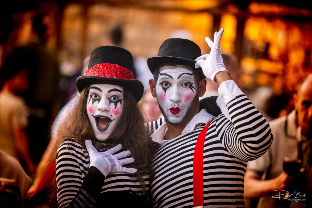 Twee harlekijns poseren tijdens een evenement, vastgelegd door een professionele eventfotograaf.