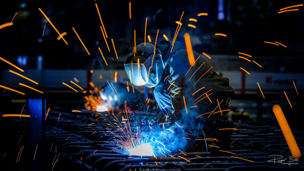 Lasser aan het werk met vonken tijdens industrieel lasproces bij een metaalbedrijf in de Waalhaven Rotterdam