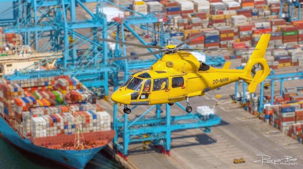 Combinatiebeeld van helicopter en container terminal. De helicopter fotografeerde ik pp de grond. Het beeld met AI samengesteld.