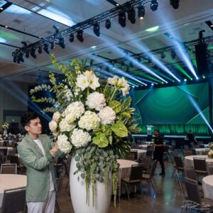AI-fotografie personal branding — bloemenstylist aan het werk in feestzaal met groot wit arrangement